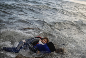 Una mare cau a l'aigua amb el seu fill arribant a l'illa grega de Lesbos